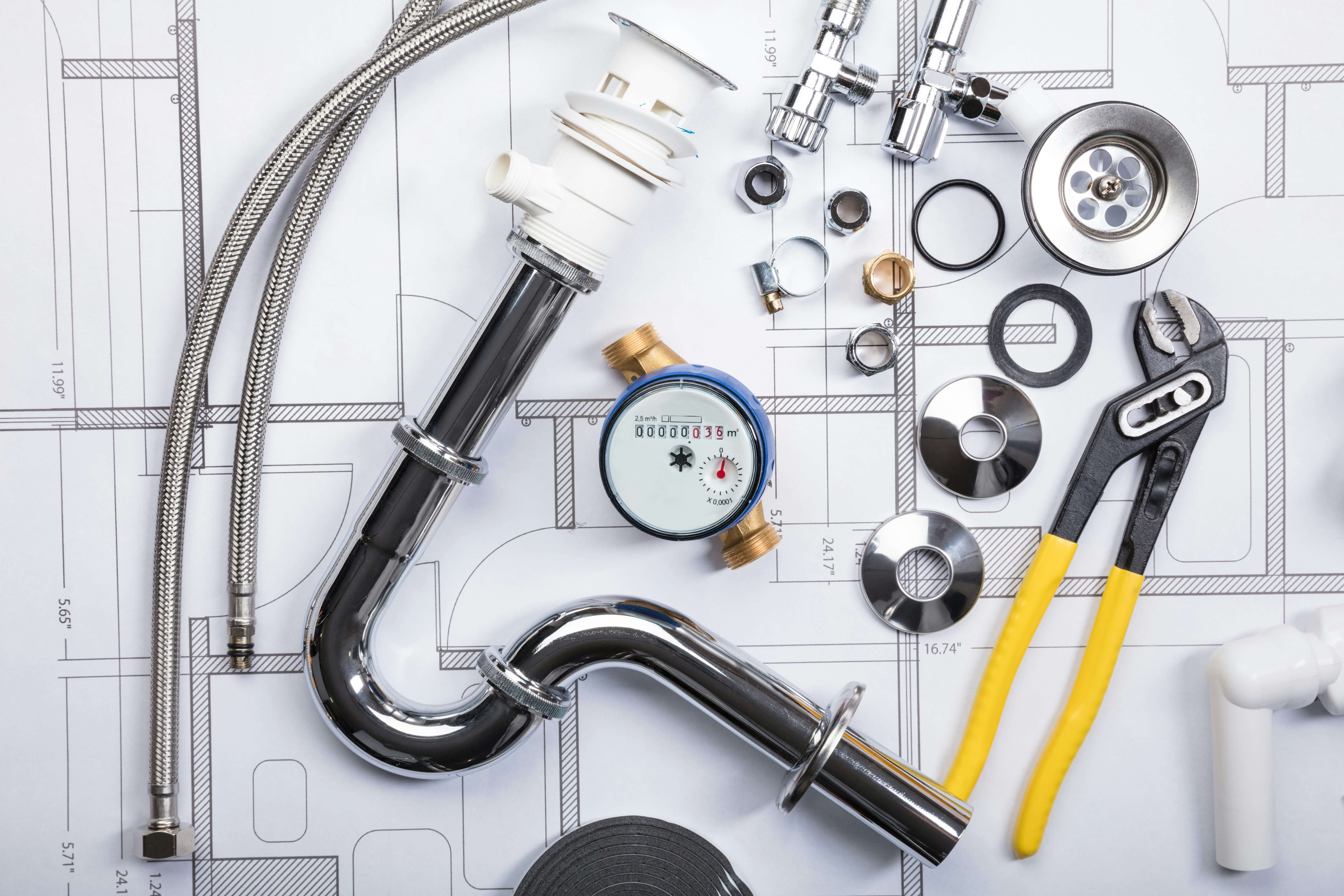 Plumbing tools arranged neatly on blueprints.